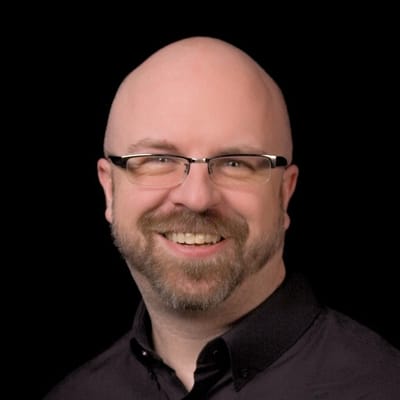 Jeff Neet, smiling, against a black background